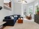 Bright living room with large windows, comfortable sofa, ceiling fan, and neutral carpet at 8450 E 29Th Ave, Denver, CO 80238