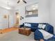 Spacious living room with hardwood floors, blue sofa, wooden coffee table, and staircase access at 8450 E 29Th Ave, Denver, CO 80238