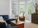 Inviting living room featuring large windows, blue sofa, decorative pillows, and neutral carpet at 8450 E 29Th Ave, Denver, CO 80238