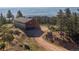 Unique log home featuring a two-car garage and a long dirt driveway on a hilltop with lush trees at 2518 N State Highway 67, Sedalia, CO 80135