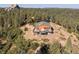 A charming wooden house with a green roof and a spacious deck surrounded by lush trees and a large rock formation at 2518 N State Highway 67, Sedalia, CO 80135