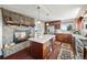 Cozy kitchen featuring stainless appliances, granite countertops, a stone fireplace, and hardwood floors at 2518 N State Highway 67, Sedalia, CO 80135