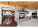 Open-concept living space with a stone fireplace, hardwood floors, and a view into the kitchen at 2518 N State Highway 67, Sedalia, CO 80135
