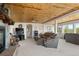 Cozy living room featuring a wood-paneled ceiling, stone fireplace, and comfortable seating at 2518 N State Highway 67, Sedalia, CO 80135