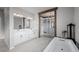 A luxurious bathroom with a double vanity, a soaking tub, and a walk-in closet with custom shelving at 6696 Kenzie Cir, Castle Pines, CO 80108