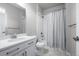 A bright bathroom features a single vanity, toilet and shower with shower curtain at 6696 Kenzie Cir, Castle Pines, CO 80108