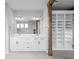 A bright bathroom features a double vanity with undermount sinks and white cabinets and shelving at 6696 Kenzie Cir, Castle Pines, CO 80108