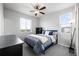 A comfortable bedroom features a ceiling fan, plush bedding, and natural light at 6696 Kenzie Cir, Castle Pines, CO 80108