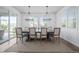 Elegant dining room showcasing natural light, stylish chandelier, and ample seating on a plush rug at 6696 Kenzie Cir, Castle Pines, CO 80108