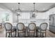 Bright, modern kitchen with a large island, white cabinetry, and stylish pendant lighting at 6696 Kenzie Cir, Castle Pines, CO 80108