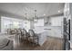Modern kitchen with a large island, dining area, stainless steel appliances and open floor plan at 6696 Kenzie Cir, Castle Pines, CO 80108