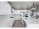 Bright kitchen features white cabinetry, stainless steel appliances, and a spacious center island with a quartz countertop at 6696 Kenzie Cir, Castle Pines, CO 80108