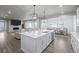 Open concept kitchen with a large island, white cabinets, and seamless flow to living areas at 6696 Kenzie Cir, Castle Pines, CO 80108
