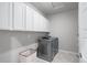 Well-organized laundry room featuring upper cabinets, a side door, and modern washer and dryer at 6696 Kenzie Cir, Castle Pines, CO 80108