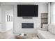 Modern fireplace framed by light tile, with a flatscreen and floating shelves at 6696 Kenzie Cir, Castle Pines, CO 80108
