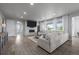 Living room with a fireplace, large sectional, hardwood floors and natural lighting at 6696 Kenzie Cir, Castle Pines, CO 80108