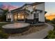 Beautiful home featuring a covered patio, hot tub, lush lawn, and a curved concrete patio at 6696 Kenzie Cir, Castle Pines, CO 80108