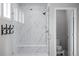 A marble shower with glass door, built in bench and rainfall shower head at 6696 Kenzie Cir, Castle Pines, CO 80108