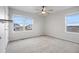 Bright bedroom with a ceiling fan, two windows, and neutral carpet flooring at 5842 High Timber Cir, Castle Rock, CO 80104