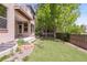 Well-maintained backyard with artificial lawn, stepping stones, privacy fence, and covered porch at 6700 W Dorado Dr # 41, Littleton, CO 80123