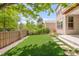 Lush backyard with artificial grass, a privacy fence, stepping stones, and mature trees at 6700 W Dorado Dr # 41, Littleton, CO 80123