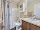 Bathroom features modern fixtures, storage cabinet, tub with curtain, and tan walls at 2508 Coach House Loop, Castle Rock, CO 80109