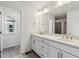 Bathroom featuring double vanity with white cabinets and white countertops, plus luxury vinyl plank flooring at 9277 Truckee Ct, Commerce City, CO 80022