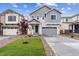 Charming two-story home features a manicured lawn, gray siding, and an attached two-car garage at 9277 Truckee Ct, Commerce City, CO 80022
