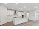 Modern kitchen with white cabinets, an island with seating, and stainless steel appliances at 9277 Truckee Ct, Commerce City, CO 80022