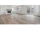 Bright, open-concept living room with hardwood flooring, access to backyard, and a modern fireplace at 9277 Truckee Ct, Commerce City, CO 80022