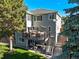 Rear exterior view showcasing the deck, patio, and landscaped backyard with mature trees at 6242 Shea Pl, Highlands Ranch, CO 80130