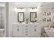 Elegant bathroom featuring a dual vanity, modern fixtures, and a standalone bathtub in an elegant setting at 6242 Shea Pl, Highlands Ranch, CO 80130