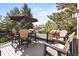 Relax on this beautifully styled deck featuring cozy seating, flower boxes, and a large umbrella for shade at 6242 Shea Pl, Highlands Ranch, CO 80130