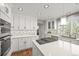 Bright, modern kitchen with white cabinets, stainless steel appliances, and a large island at 6242 Shea Pl, Highlands Ranch, CO 80130