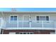 Front view of a light gray building with a balcony and brick base at 3705 Quail St # 4, Wheat Ridge, CO 80033