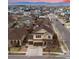 Aerial view of a two-story home in a neighborhood with sunset sky and mountain views at 10995 Quintero St, Commerce City, CO 80022