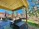 Relaxing backyard patio with outdoor seating, string lights, and a view of the lush lawn at 10995 Quintero St, Commerce City, CO 80022