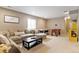 Finished basement with a large sectional sofa and multiple game tables for recreation at 10995 Quintero St, Commerce City, CO 80022