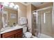 Cozy bathroom featuring a single sink vanity and glass shower with neutral tile at 10995 Quintero St, Commerce City, CO 80022