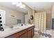 Bathroom with double vanity, bathtub with shower, and cute smiley face shower curtain at 10995 Quintero St, Commerce City, CO 80022