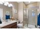 Bathroom featuring a glass-enclosed shower, vanity with solid surface counter, and neutral decor at 10995 Quintero St, Commerce City, CO 80022