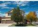 Inviting two-story home with a well-maintained yard, mature trees, and a two-car garage at 10995 Quintero St, Commerce City, CO 80022