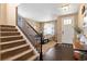 Welcoming home foyer featuring hardwood floors, a staircase with wooden railings, and a view into the living room at 10995 Quintero St, Commerce City, CO 80022