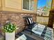 Cozy front porch featuring stone accents, stylish seating, and a decorative potted plant at 10995 Quintero St, Commerce City, CO 80022