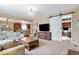 Open-concept living room with seamless transition to the kitchen, a sliding barn door, and hardwood floors at 10995 Quintero St, Commerce City, CO 80022