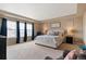 Spacious main bedroom with large windows, plush carpeting, and neutral color scheme at 10995 Quintero St, Commerce City, CO 80022