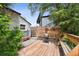 Backyard with a built-in wooden deck with seating and a grill for cooking outdoors at 1456 Syracuse St, Denver, CO 80220