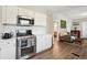 Updated kitchen boasts stainless steel appliances, white cabinetry, and hardwood style flooring at 1456 Syracuse St, Denver, CO 80220