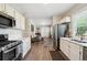 Open kitchen flowing into living room, featuring white cabinets and modern appliances at 1456 Syracuse St, Denver, CO 80220