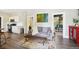Open-concept living room with modern decor, grey sofa, and a view into the kitchen at 1456 Syracuse St, Denver, CO 80220